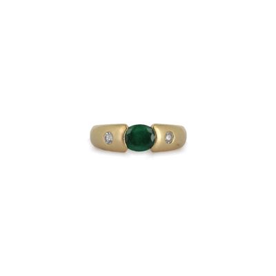gros plan d'une bague en or avec une pierre verte et des diamants