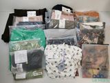 many bags of clothing that are on a table