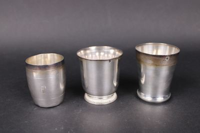 trois coupes en argent posées les unes à côté des autres sur une surface noire
