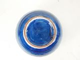 a blue plate with a brown rim on a white table