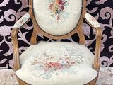 une image représentant une chaise dont l'assise est recouverte d'un tissu à motifs floraux, posée sur un tapis