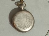 a silver pocket watch with a chain around it