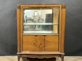 a wooden display cabinet with glass shelves and drawers