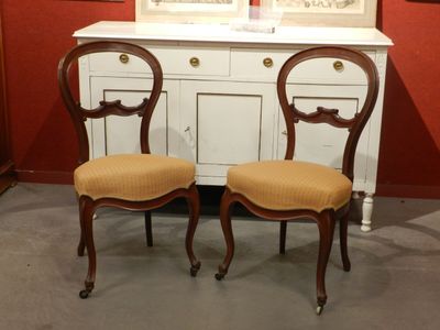 deux chaises placées l'une à côté de l'autre devant une armoire