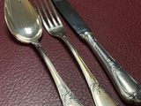 three spoons and a fork on a red table