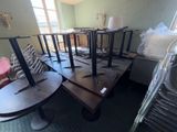 many tables and chairs in a room with a bed in the background