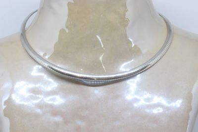 a silver necklace that is on a mannequin head