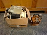 une boîte posée par terre, contenant un téléphone et d'autres objets
