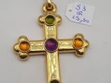 un gros plan d'une croix en or ornée de pierres multicolores