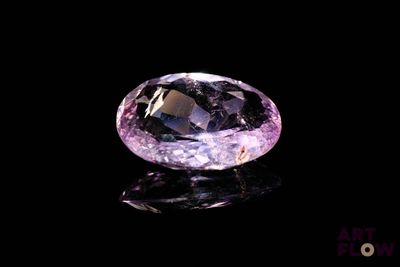 a close up of a purple diamond on a black surface