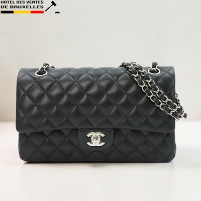 un sac Chanel noir auquel est suspendue une chaîne