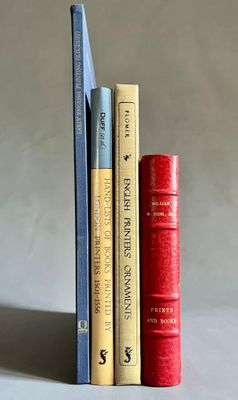 trois livres sont empilés sur une table