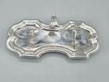 a silver plate with a bat shaped handle on top of it