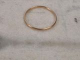 un gros plan d'une bague en or posée sur une surface en marbre