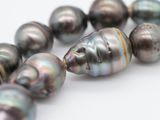 a close up of a strand of pearls on a white surface