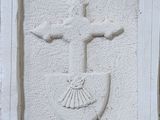une croix et un bouclier sur le mur d'un bâtiment
