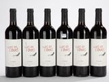 six bouteilles de vin sont alignées sur une surface blanche