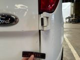 a close up of a person ' s hand holding a remote control on a white car