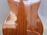 a close up of a wooden guitar on a white background