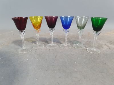 six different colored wine glasses lined up in a row