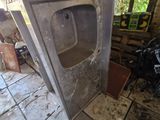 a broken sink in the middle of a dirty room