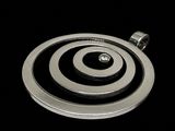 a silver pendant that has a black and white design on it