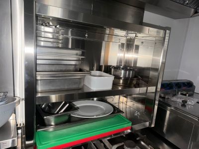a kitchen with a stove, sink, and pots and pans in it