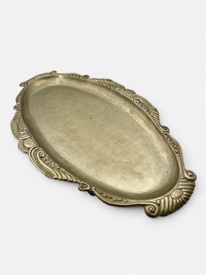 un plateau ancien en laiton orné d'un motif décoratif sur le bord