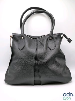 black leather handbag with zippers and handles on a white background