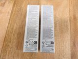 two tubes of toothpaste sitting on a wooden surface