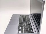 a silver laptop with a black keyboard on a white surface