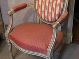 a red and white striped chair sitting in front of a fireplace
