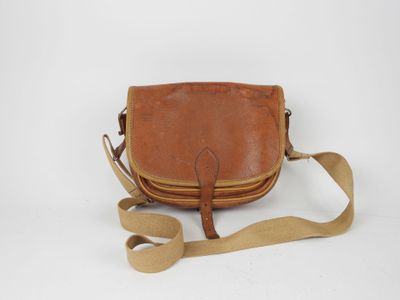 an old brown leather purse with a strap on a white background