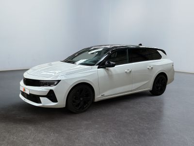 Une voiture blanche est garée dans une pièce blanche au sol noir.