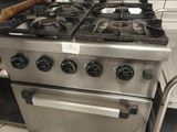une cuisinière en acier inoxydable et un chariot dans une cuisine