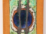 an orange canvas with a painting of a tree in the center