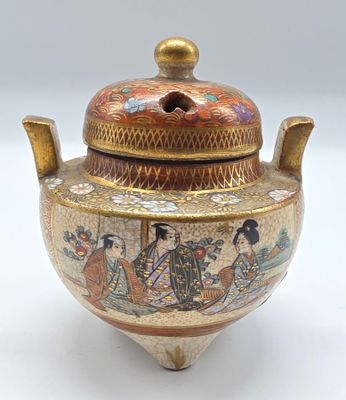 un petit vase muni d'un couvercle orné d'une peinture