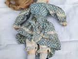 a doll that is laying down on a white sheet