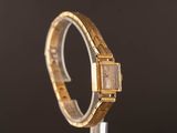 a close up of a watch on a stand with a black background