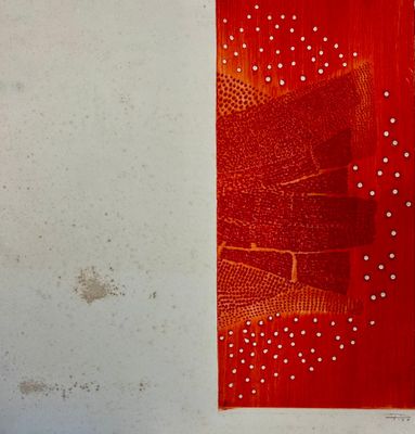 a red piece of art hanging on a white wall