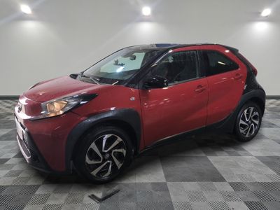 La Toyota C-HR rouge est garée sur un sol à damier.