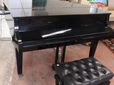 a black piano and a stool in a room