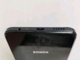 a close up of the back of a black phone on a white surface