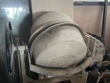 a cement mixer sitting in the middle of a pile of junk