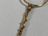a close up of a gold key on a white surface