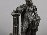 a statue of a man standing next to a book shelf