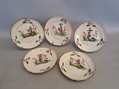 quatre assiettes ornées de fleurs et d'oiseaux, posées sur une table