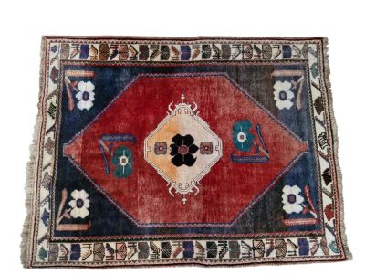 un vieux tapis orné d'un motif floral sur fond blanc