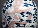 a vase with a dragon on it sitting on a table