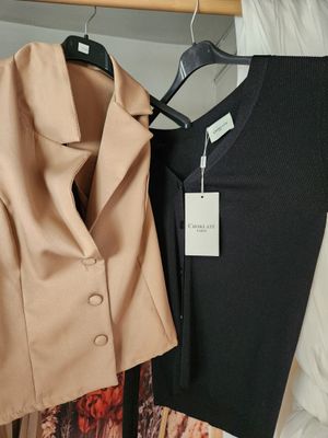 deux vestes suspendues à un portant dans un placard